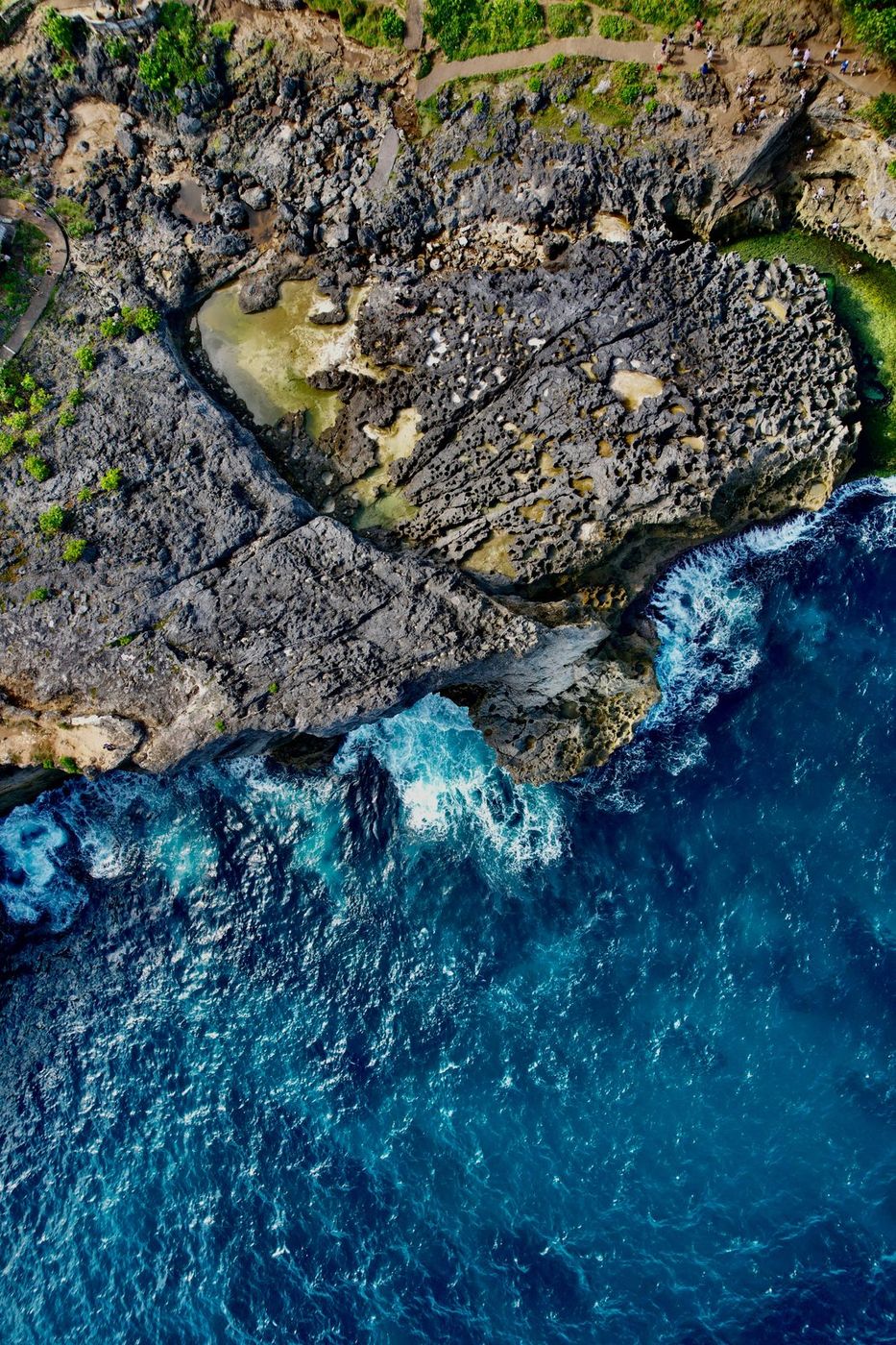 Aerial shot of Broken Beach, Bali, coastal cliffs and turquoise water.