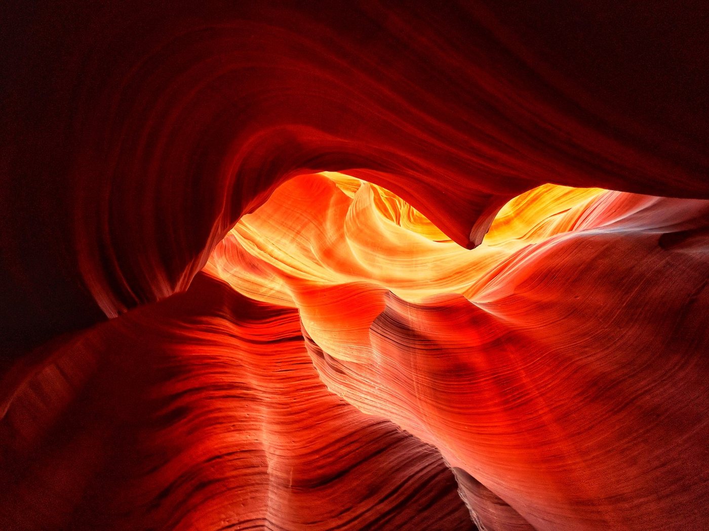 Antelope Canyon slot canyon walls lit in warm red and gold light.